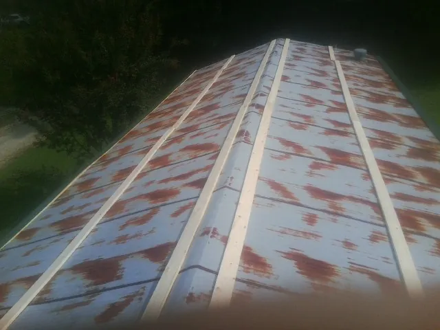 Rusted metal roof panels with new wood purlins before replacement — Storm Damage Roof Repair in Mossville by Roofing Brothers