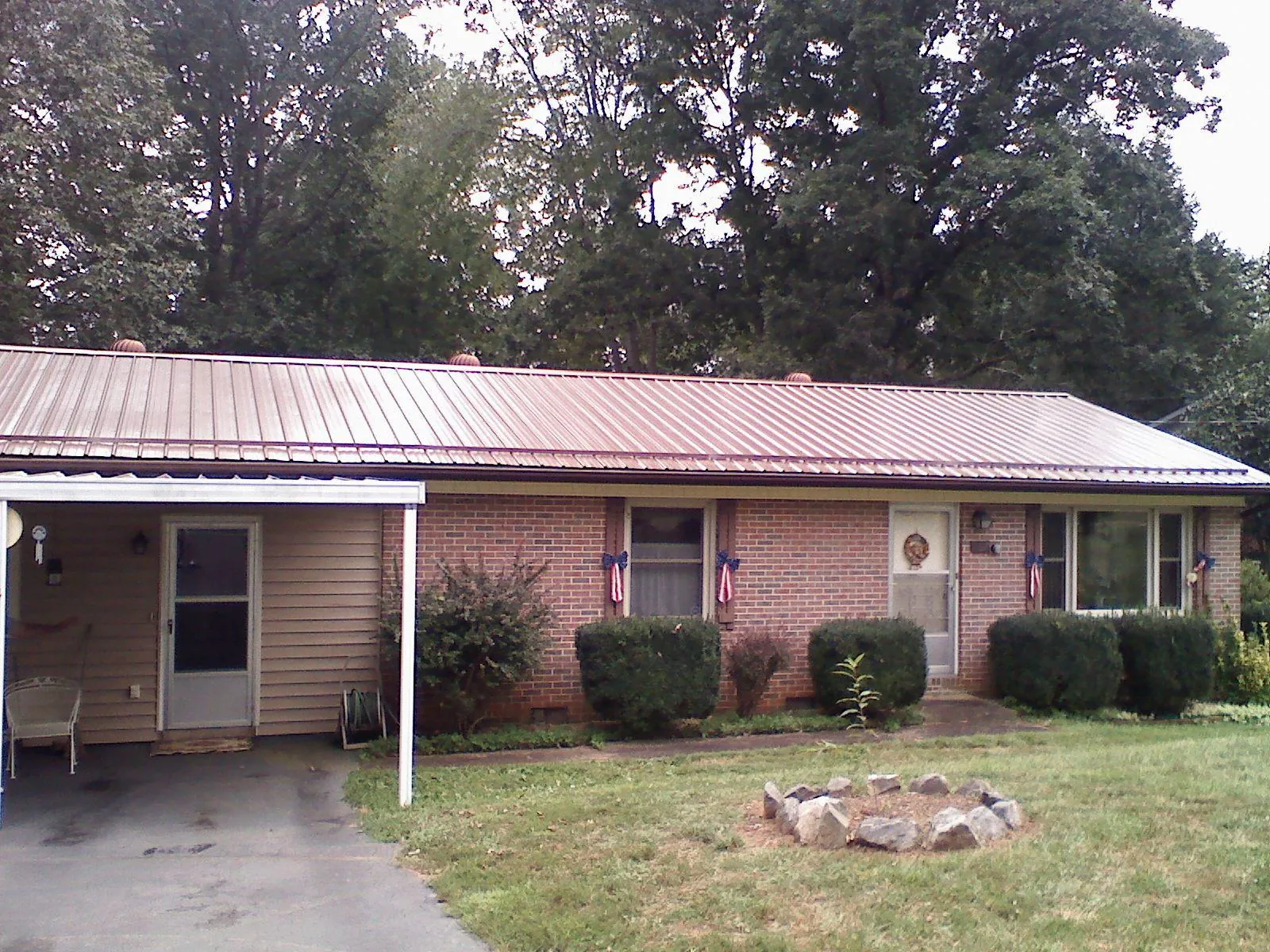 Bronze metal roof and carport on a brick ranch home — Roof Repair work by our crew in Mossville