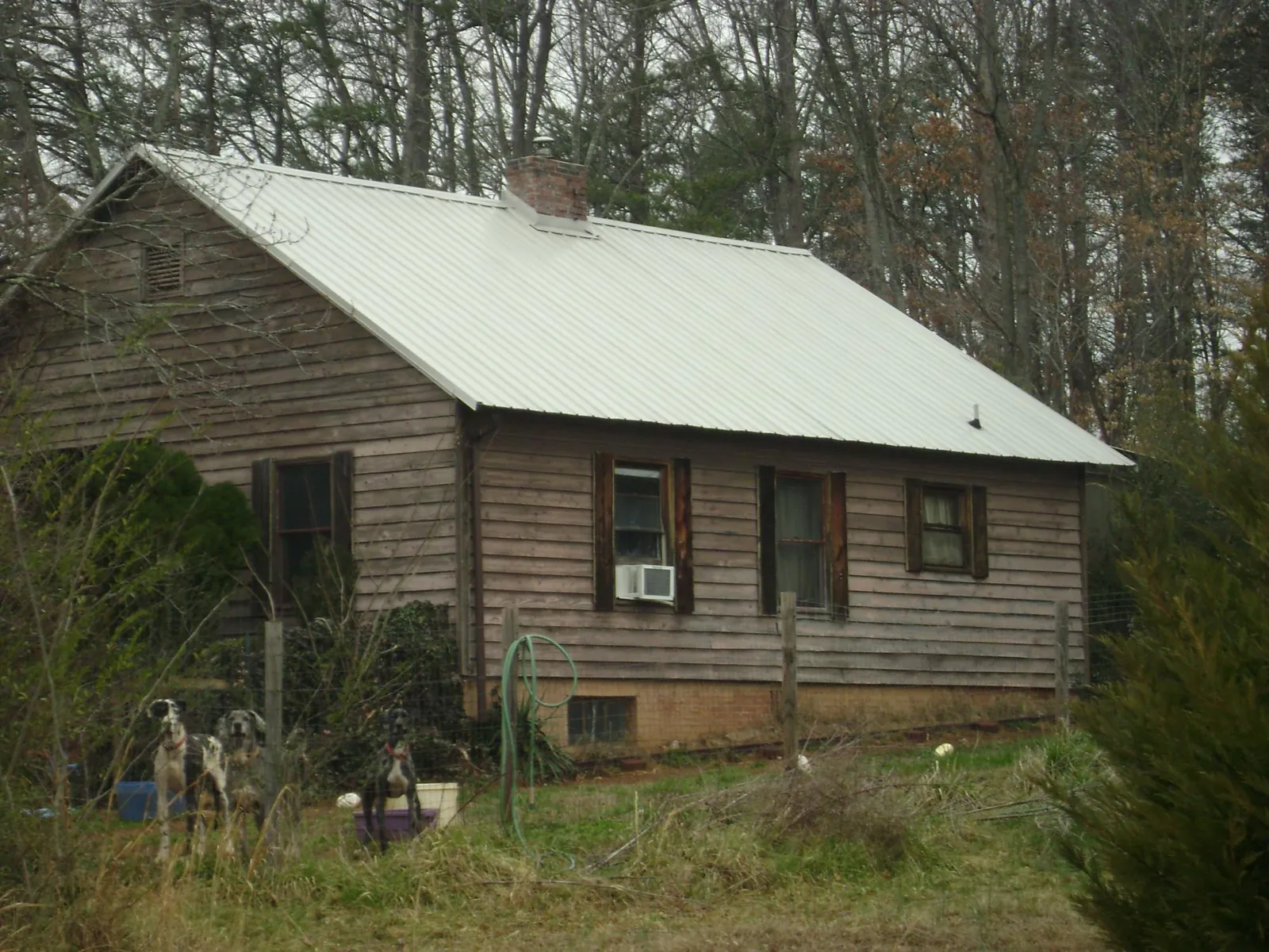 White metal roof on an old wood sided farmhouse, from a Metal Roof Installation job in Mossville